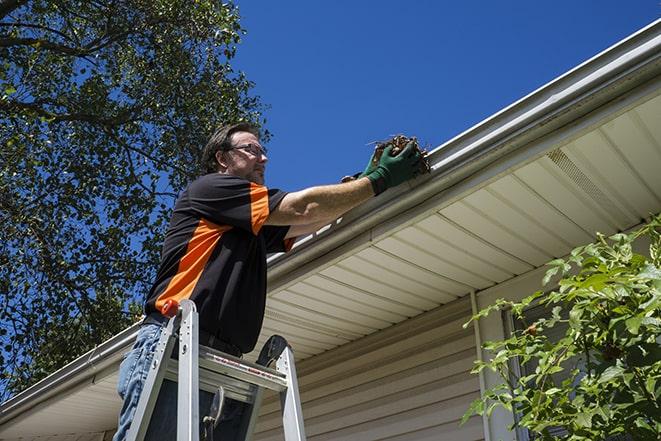 gutter repairman fixing a leaky drain in Chagrin Falls